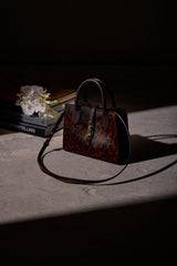 Bailey Mini Bag in cheetah print calf hair resting on a table in a softly lit, dark interior