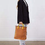 Model holding the Gisele Large Shopper in tan suede by its top handles