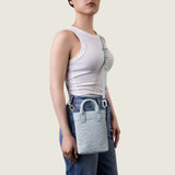 Model wearing the Lola Mini Shopper in light blue ostrich crossbody