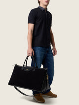 Man carrying the Maverick Weekender in black suede