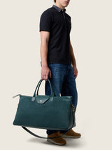 Man carrying the Maverick Weekender in bottle green suede
