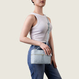 Model wearing the Mia Vanity Bag in light blue ostrich crossbody