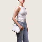 Model wearing the Taylor Mini Clutch in white ostrich crossbody