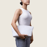 Model holding the Blake Large Clutch in white ostrich at her side