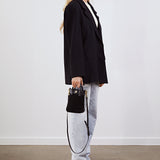 Model holding the Lola Mini Shopper in black suede by its top handles