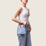 Model wearing the Lola Mini Shopper in blue suede crossbody