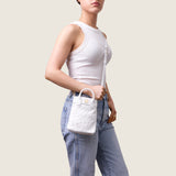 Model wearing the Lola Mini Shopper in white ostrich crossbody