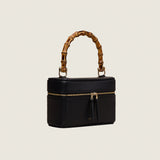 Mia Vanity Bag in black nappa leather with bamboo handle and gold zipper, three-quarter view