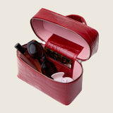Mia Vanity Bag in cherry red alligator unzipped to show the pink interior holding beauty essentials