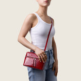Model wearing the Mia Vanity Bag in cherry red alligator crossbody