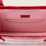 Interior of the Molly Mini Book Tote in cherry red alligator showing the pink lining and slip pocket