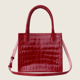 Molly Mini Book Tote in cherry red alligator with its shoulder strap attached