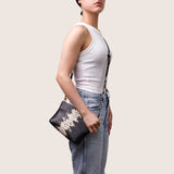 Model wearing the Taylor Mini Clutch in black and camel python-embossed leather crossbody