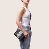 Model wearing the Taylor Mini Clutch in black and lime python-embossed leather crossbody